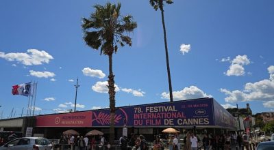 Pedestres passam por um estande de credenciamento à margem da 79ª edição do Festival de Cinem...