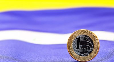 1 de 1 Imagem colorida de uma moeda de 1 real sobre uma bandeira do Brasil - Metrópoles - Foto: ...